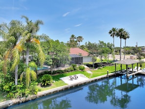 Relax by the serene pool surrounded by lush vegetation and palm trees.