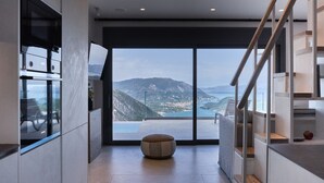 A modern interior with a large window offering a mountain view. - Escape View Villa Lefkada (Fterno)