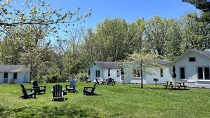 Un terrain de camping comprenant plusieurs petits chalets, des espaces de repos en plein air et une zone herbeuse.