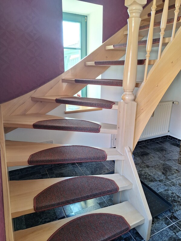 A wooden staircase with a handrail and carpeted steps. - "Schwalbennest" modern, air-conditioned vacation apartment, close to Plau am See. (Klein Wangelin)