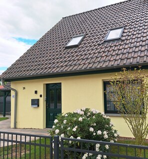 A building with a tiled roof, a green door, and a small window. - "Schwalbennest" modern, air-conditioned vacation apartment, close to Plau am See. (Klein Wangelin)