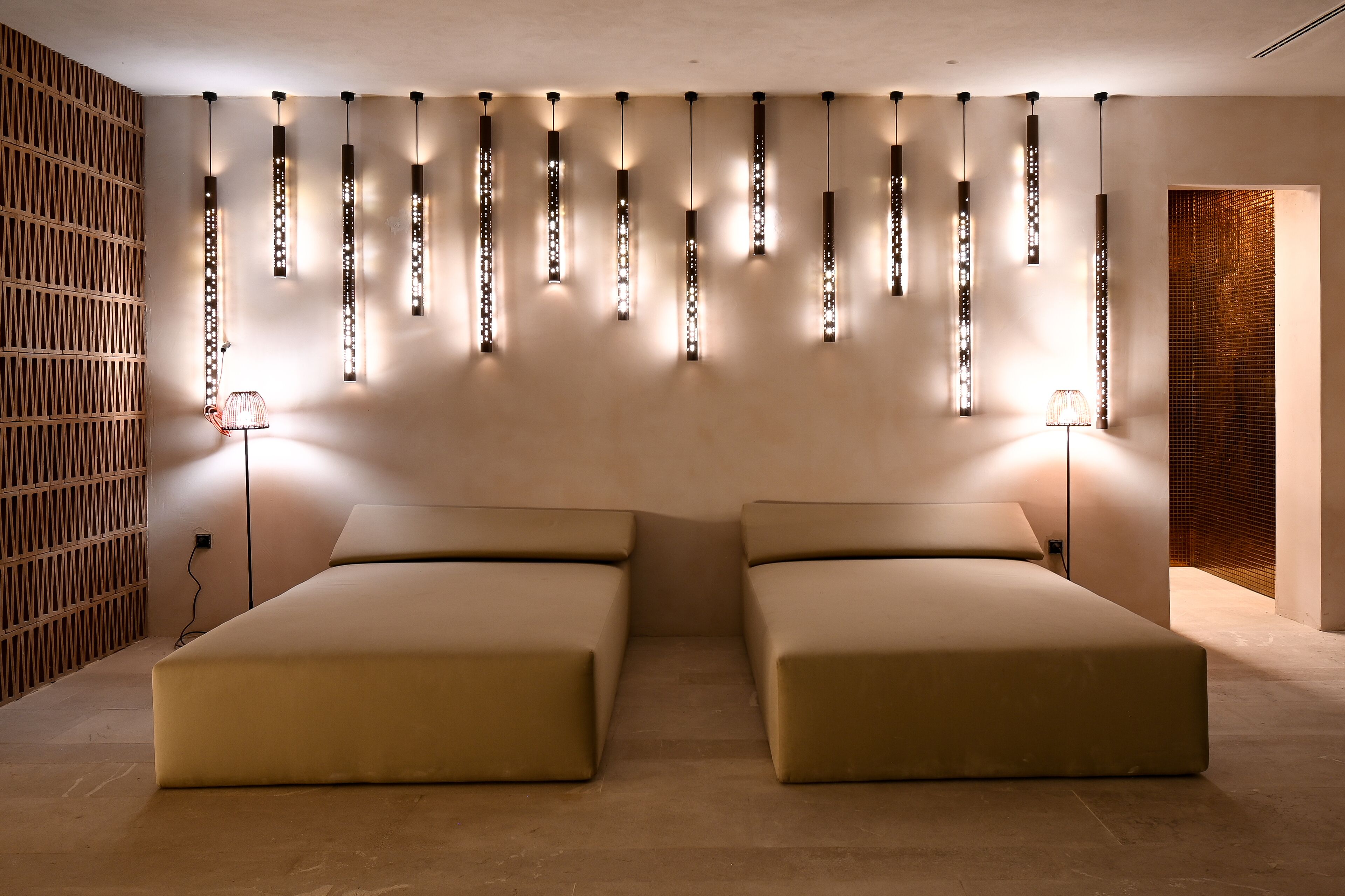 A modern room with two beds, a wooden wall, and a patterned wall.