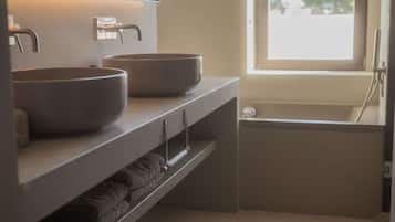 Ein Badezimmer mit zwei Waschbecken, einem Handtuchhalter und einer Badewanne.