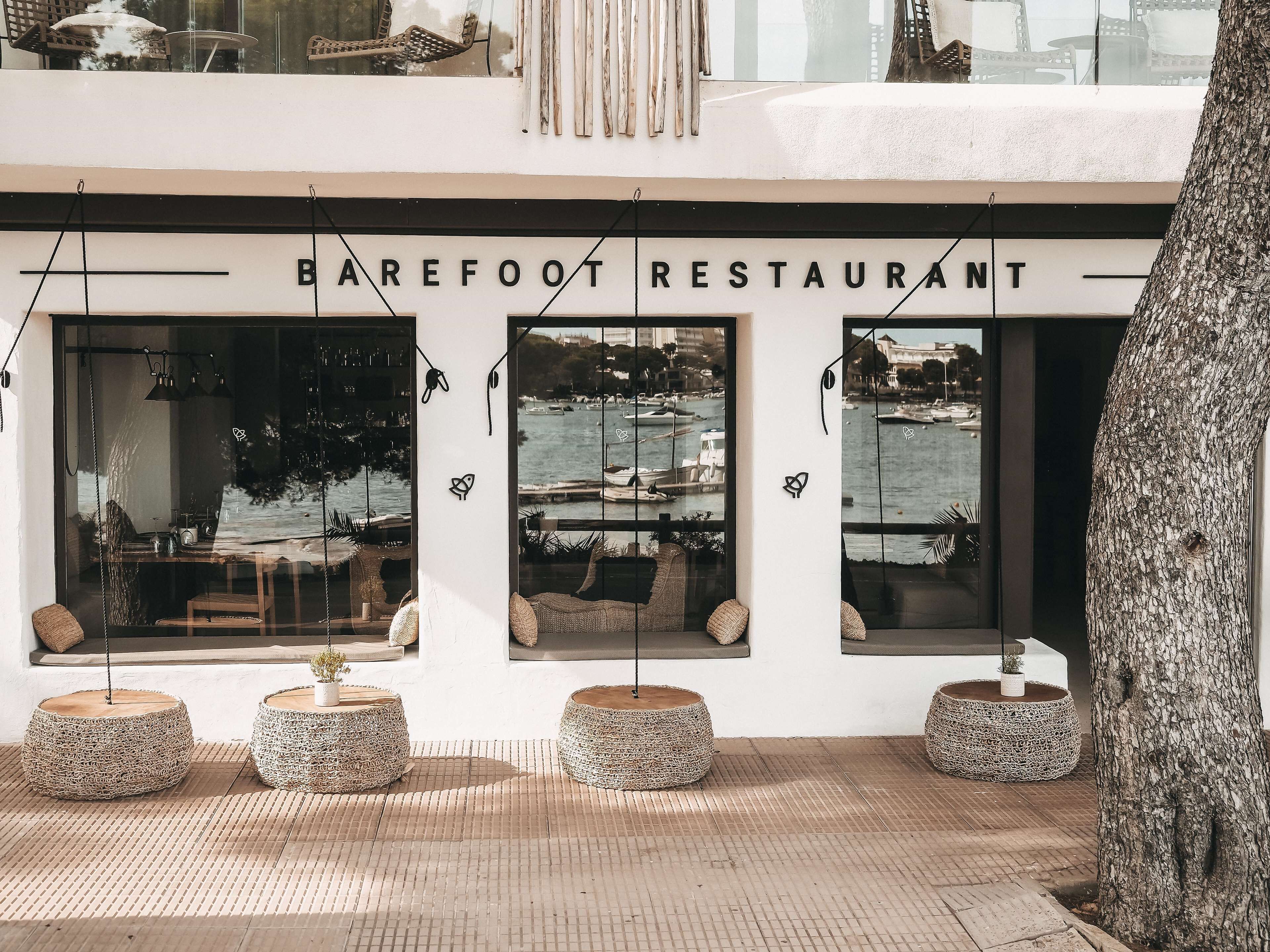 The exterior of Barefoot Restaurant with large windows offering views of the marina.