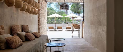 A modern interior with a stone wall, a sofa with brown cushions, and a small round table.