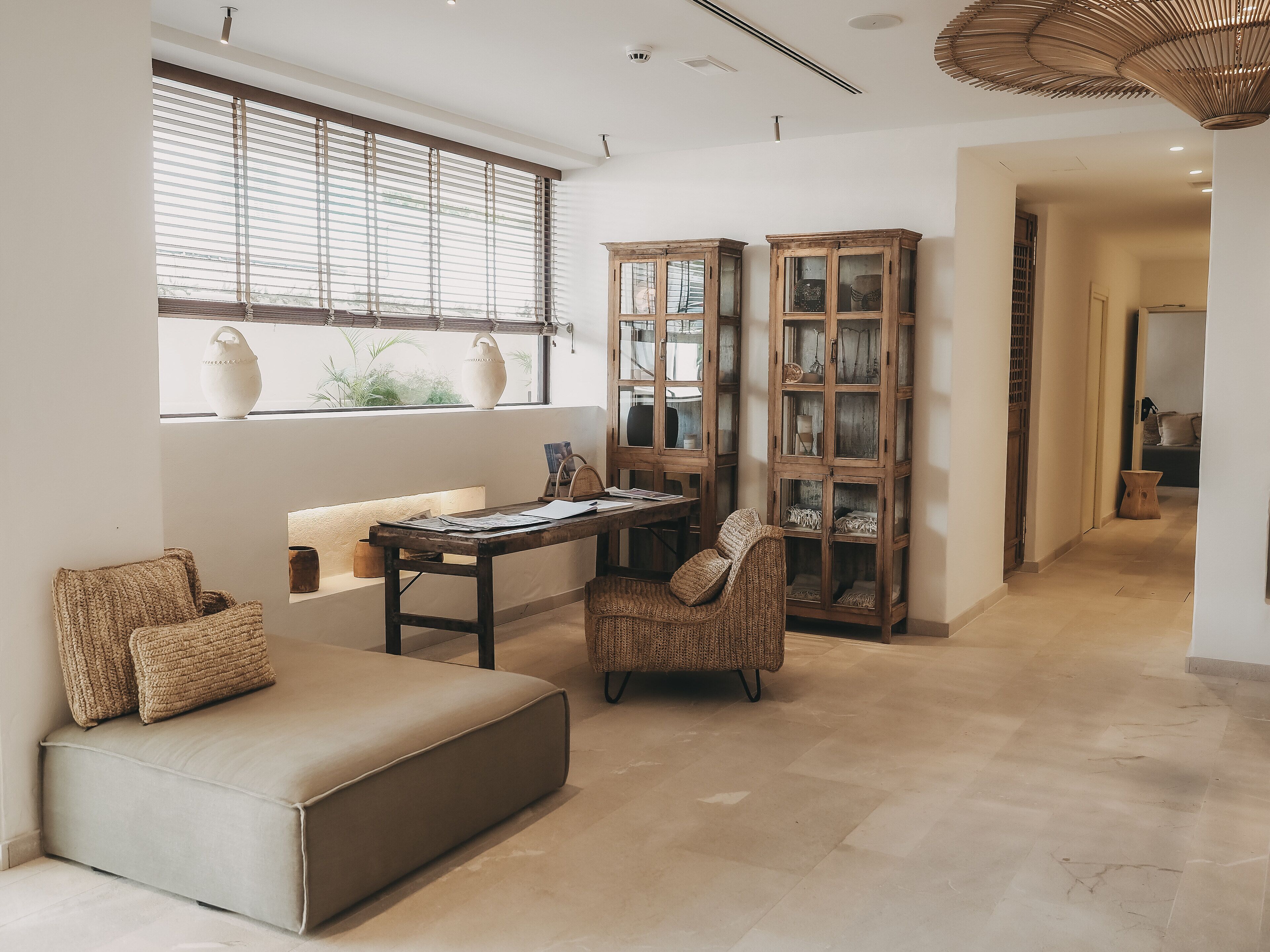 A modern living room with a sofa, a dining table, and a cabinet.