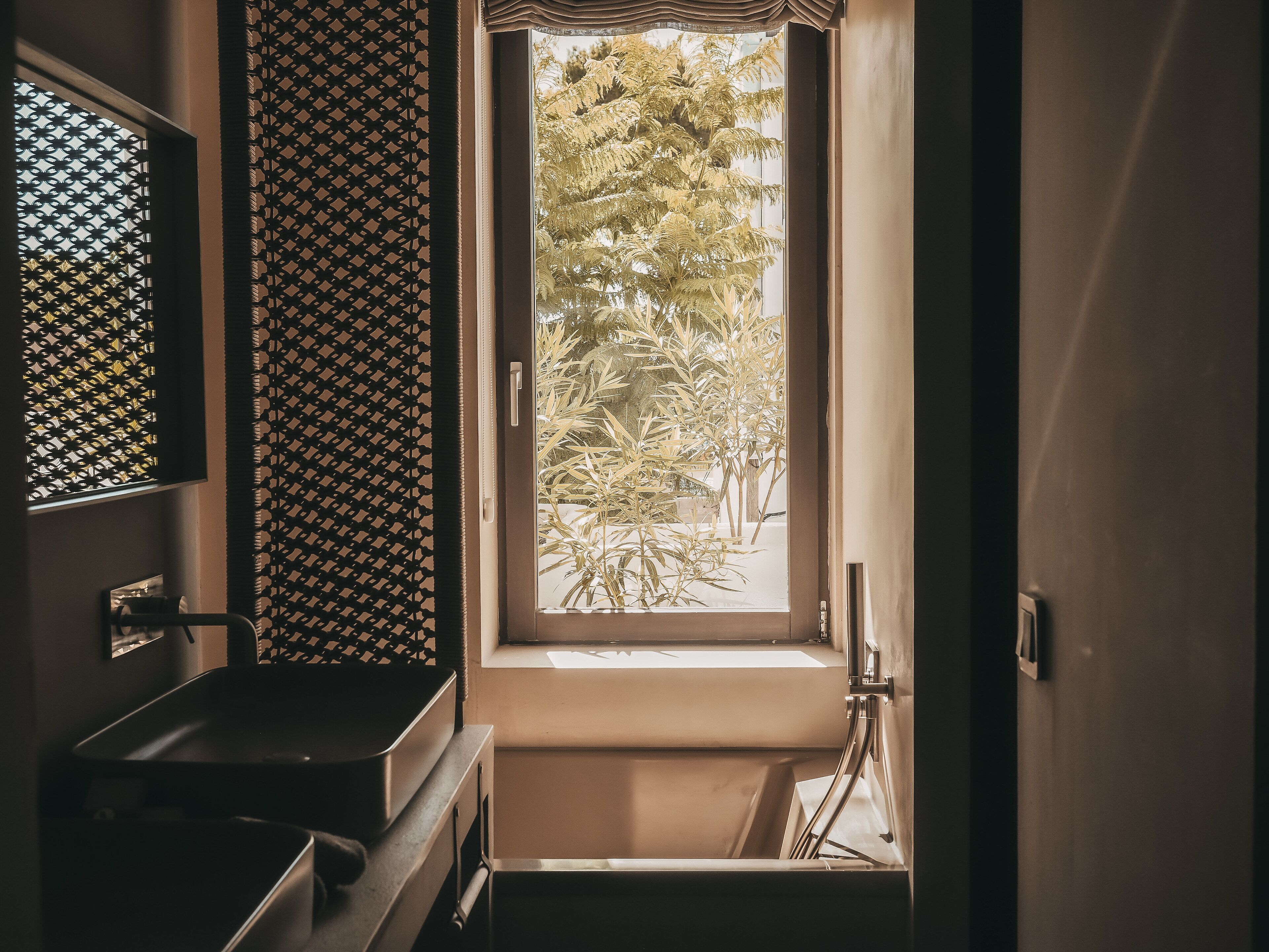 A bathroom with a window, a sink, and a toilet.