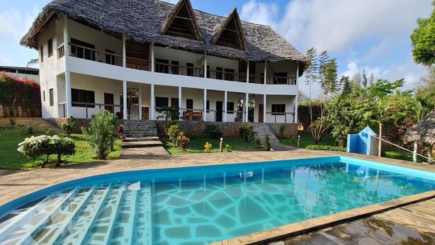 Ein zweigeschossiges Haus mit einem Pool davor.
