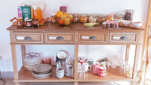 Ein Holztisch mit verschiedenen Küchenutensilien, darunter Gläser, Schüsseln und Teller.