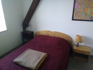 Cozy retreat with a single bed, nightstand, and lamp, perfect for a peaceful stay.