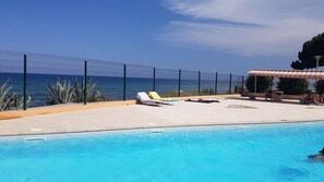 A pool area with lounge chairs and a view of the sea. - Studio les pieds dans, santa lucia (Santa-Lucia-di-Moriani)