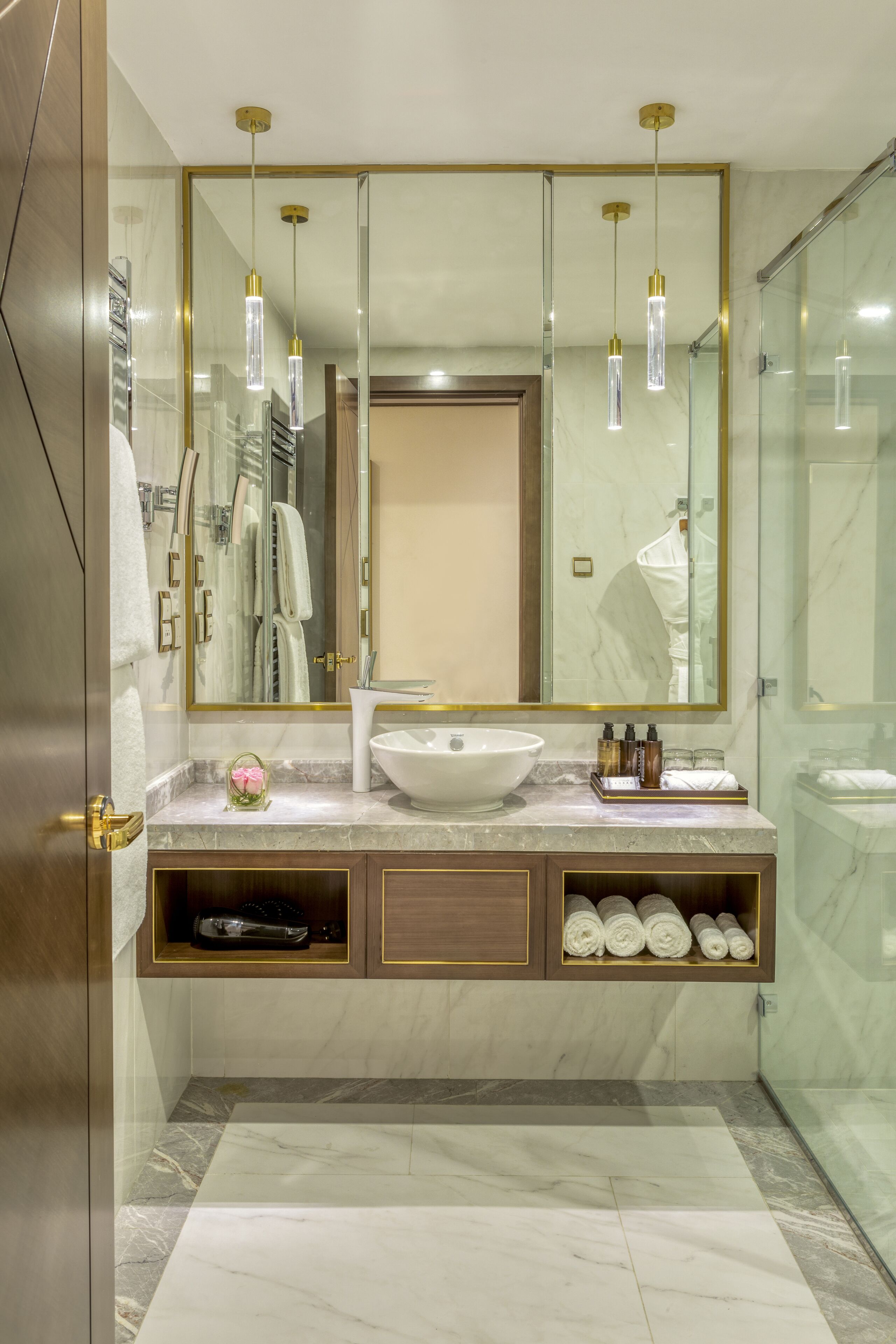 A modern bathroom with a large mirror, a vessel sink, and a glass shower enclosure.