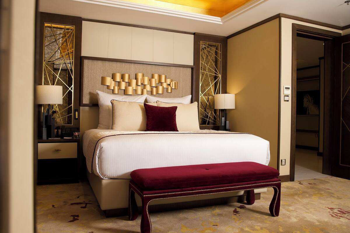A spacious bedroom with a large bed, two bedside tables, and a built-in bench.