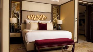 A spacious bedroom with a large bed, two bedside tables, and a built-in bench.