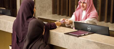 A reception desk with a laptop and a passport.