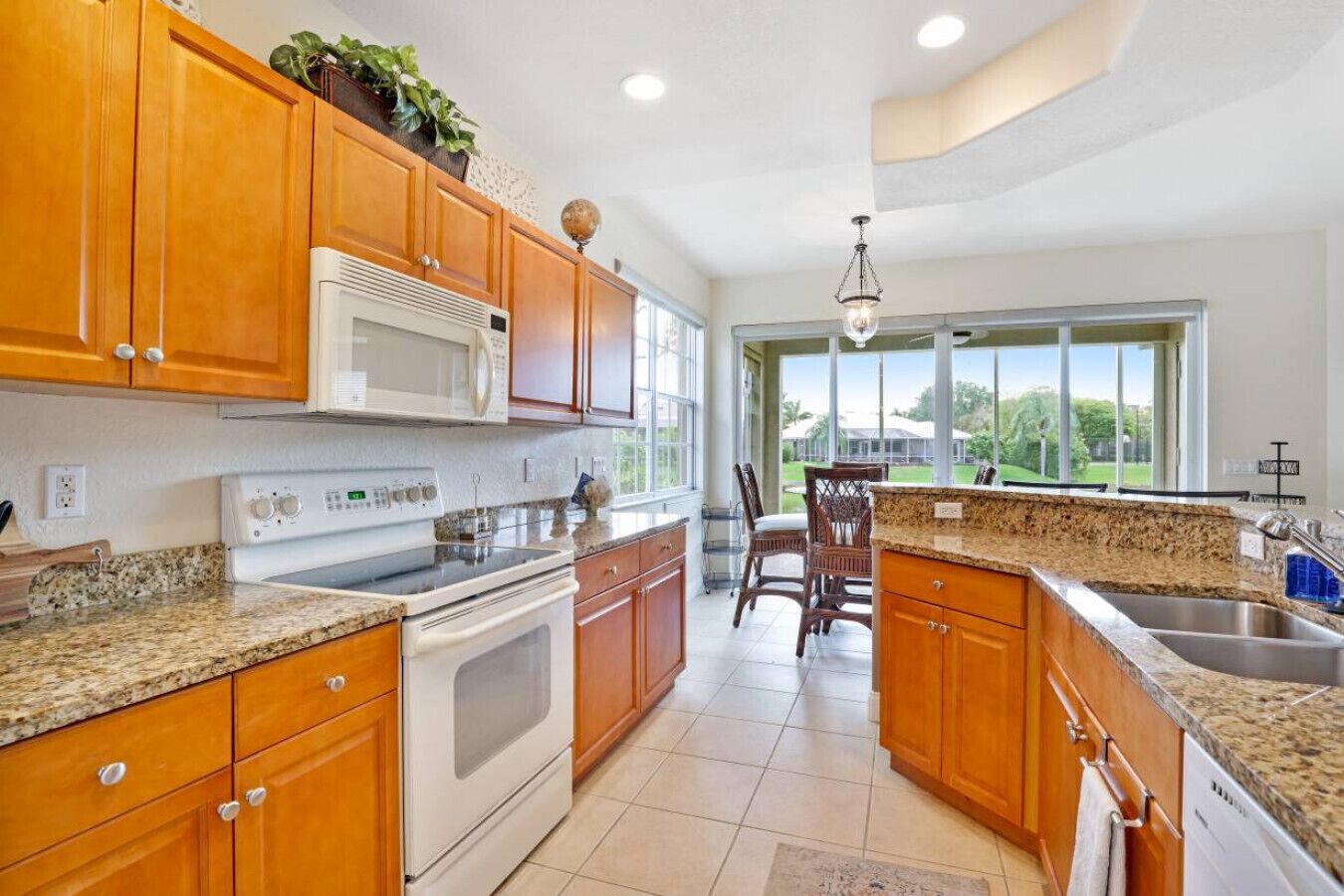 A kitchen with wooden cabinets, a microwave, stove, and granite countertops.