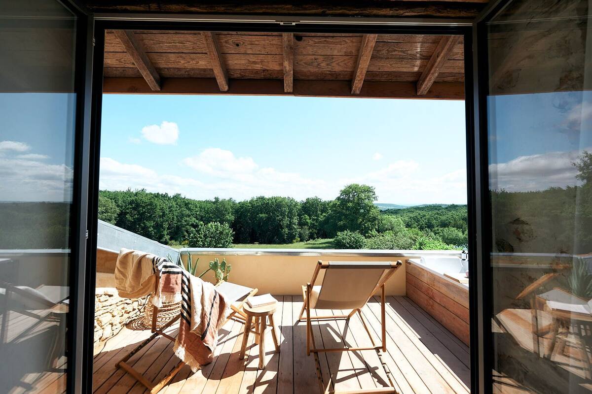 Una terraza de madera con vistas a un paisaje boscoso.