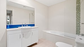 Un baño moderno con un lavabo blanco, una bañera y un inodoro.