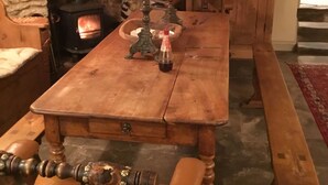A traditional wooden table with candles, a stone fireplace, and a bench. - Impeccable 3-bed 17th Century Luxury Cottage (Longhope)