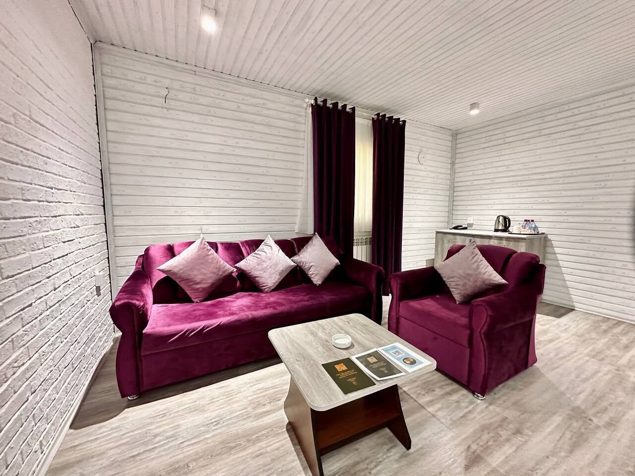 Una habitación moderna con un conjunto de sofás, una mesa de centro y una mesita auxiliar.