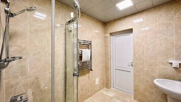 Une salle de bain moderne avec une douche à parois de verre, un lavabo et un porte-serviettes.