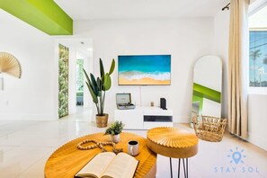 Relax in a spacious room with a large TV, comfortable seating area, and a large mirror.