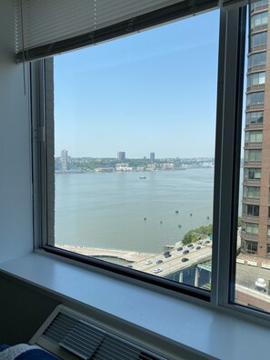 Enjoy breathtaking views of the water and surrounding cityscape from this room's expansive window.