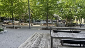 A park with hexagonal paving, wooden benches, and trees. - NYC Luxury 3bed/3 bath Westside Manhattan  (New York)