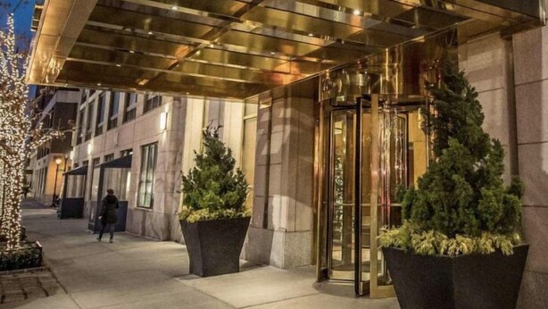 The entrance to 150 Riverside Boulevard with a modern design, featuring a glass door entrance and large potted plants. - NYC Luxury 3bed/3 bath Westside Manhattan  (New York)