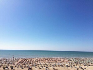 Relax on the sandy beach with comfortable sun loungers and umbrellas.