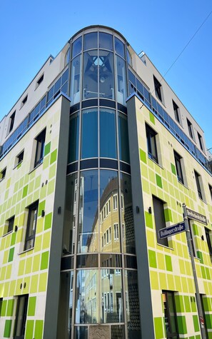 A modern building with a glass facade and a green and white checkered exterior. - Penthouse at Eco Smart Apartments (Nuremberg)