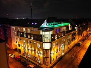 A multi-story hotel with a prominent corner section, large windows, and a rooftop terrace. - Penthouse at Eco Smart Apartments (Nuremberg)