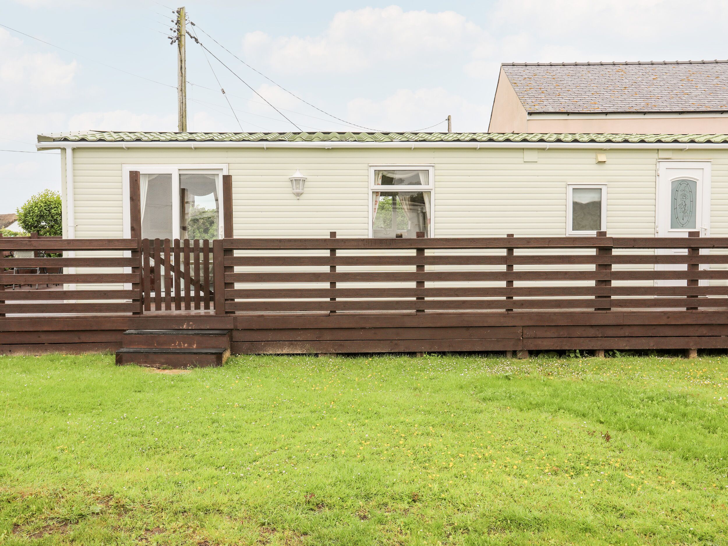 A single-story building with a light-colored exterior and a brown fence in front.
