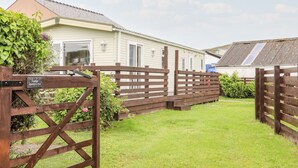 Ein Caravanpark mit einem Holztor und einem Schild mit der Aufschrift 'Lodge'.