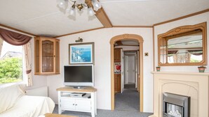 Ein gemütliches Zimmer mit Kamin, Fernseher und Bett.