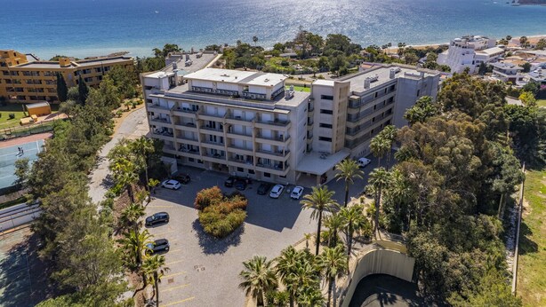 Un hôtel à plusieurs étages doté d’une terrasse sur le toit, d’un parking et offrant une vue sur la mer.