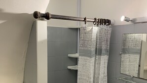A bathroom with a shower curtain, a mirror, a sink, and a towel rack. - studio 10 minutes from the beach (Olmeta-di-Tuda)