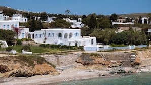 Un pueblo costero con edificios blancos, una costa rocosa y aguas azul turquesa.