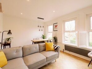 Relax in this stylish living room with a sofa, coffee table, and dining area.