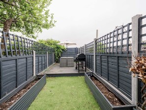 Enjoy a serene garden with a patio, barbecue grill, and seating area.
