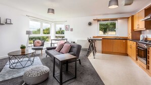 Un appartement moderne comprenant un salon, une cuisine et un coin repas.