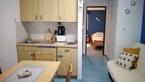 A compact room with a kitchenette, a dining area, and a bed. - Apartments Marija (Pirovac)