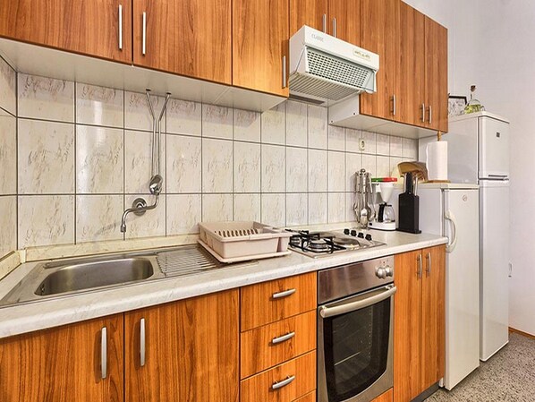 Fully equipped kitchen with a gas stove, coffee maker, and kettle.