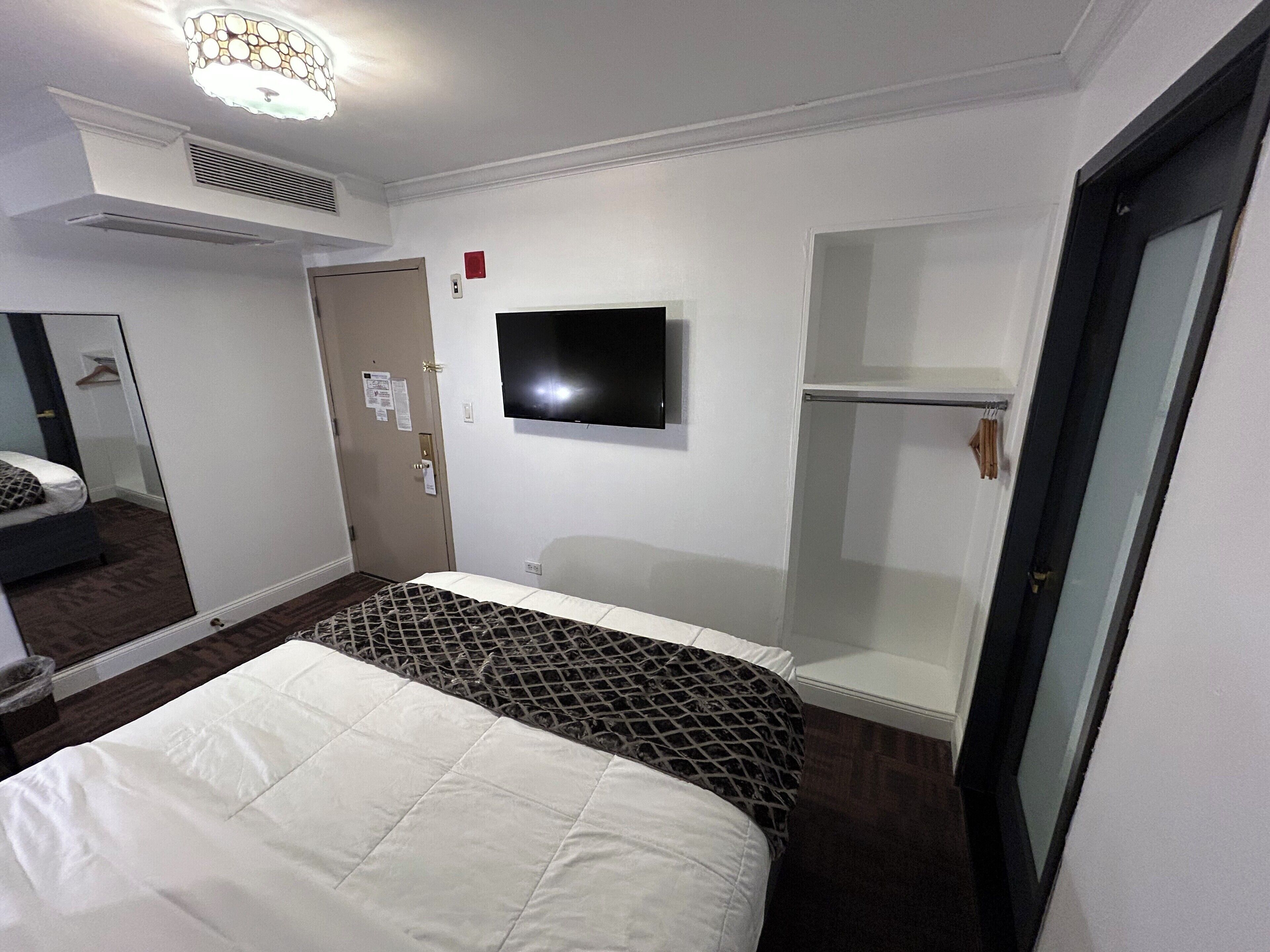 standard interior queen bed room | in-room safe, desk, laptop workspace, iron/ironing board