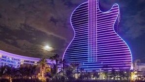 A large building with a guitar-shaped structure illuminated by vertical lights. - Sea Star Suites By The Sea #5 Steps 2 Beach & Pubs (Lauderdale-by-the-Sea)