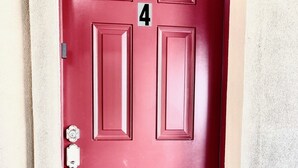 Una puerta roja con el número 4, un picaporte plateado y una cerradura.