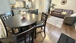 Una cocina moderna con comedor, una sala de estar con sofá y un ventilador de techo.