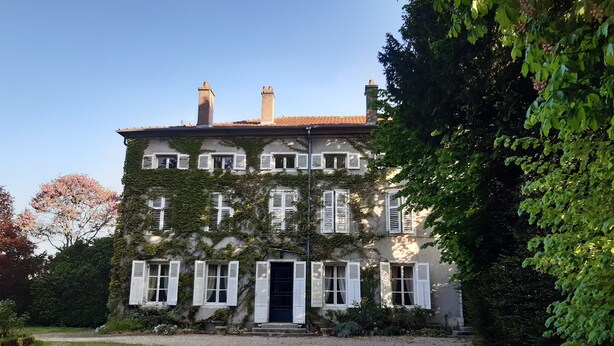 A large, multi-story building with white shutters, a gravel driveway, and lush greenery. - LOGIS HOTEL DU PARC (Pont-a-Mousson)