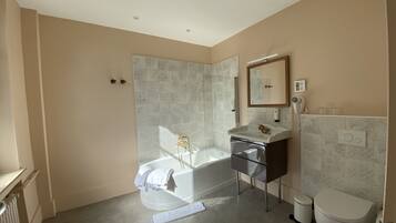 A modern bathroom with a bathtub, toilet, and sink.