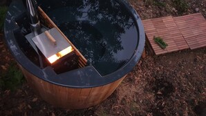 Ein Whirlpool mit Holzkonstruktion und einer kleinen Holzterrasse in der Nähe.